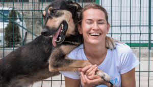 Women with dog in front of fence - Partnership DocuPet