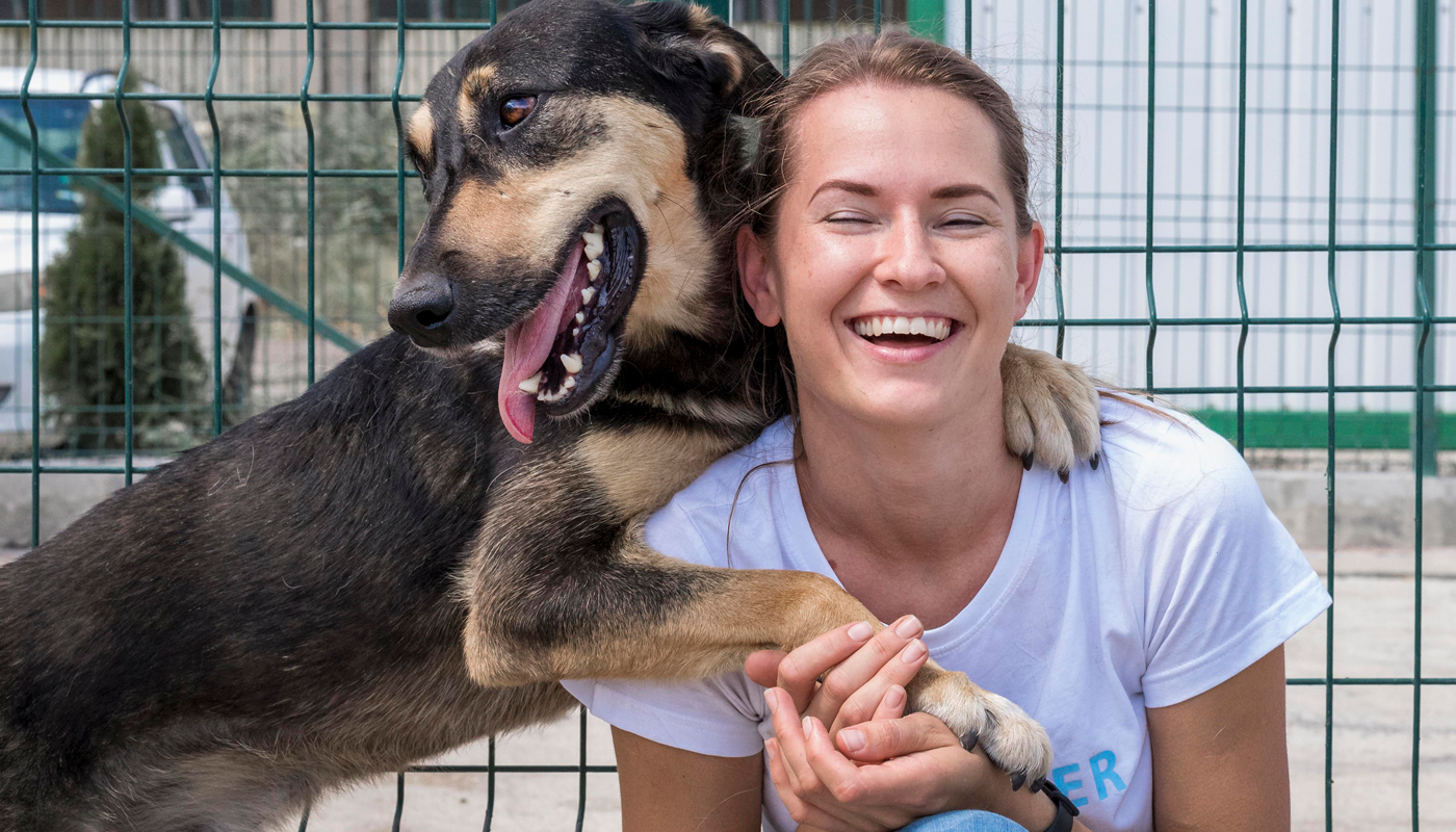 Women with dog in front of fence - Partnership DocuPet